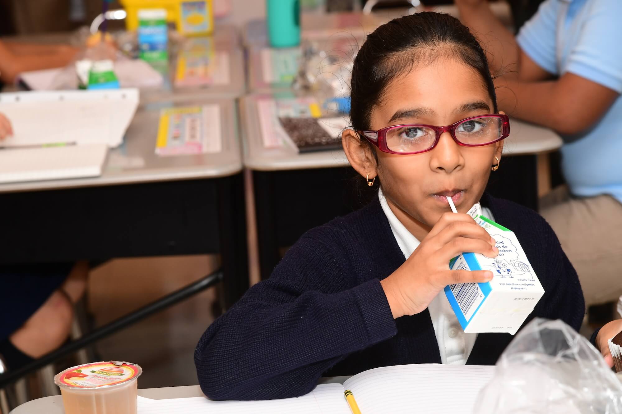 2018.10.02 Atlantic NJ Fueling Up with School Breakfast Event Photos Key shots 009 A girl wearing glasses drinks a carton of milk as part of her school lunch